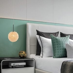 A imagem retrata o Pendente JOU da Nordecor, uma peça única que adiciona um elemento de design intrigante ao quarto. Sua composição de esferas luminosas forma uma textura detalhada e orgânica, emitindo uma luz suave que contribui para a atmosfera relaxante e estilosa do ambiente.