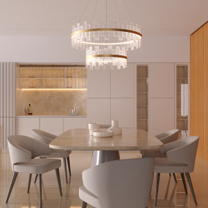 Elegant dining area with a circular marble table, six gray upholstered chairs, and a two-tier crystal chandelier above. Modern kitchen in the background.